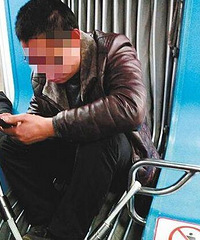 奇葩!男子蹲在轻轨连接带上玩手机游戏