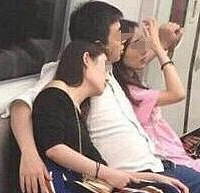 地铁上一男子左拥右抱美女
