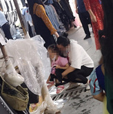 妈妈在市场给女儿把尿