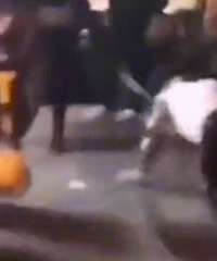 男子街头套绳被女子牵着跪行,路人围观