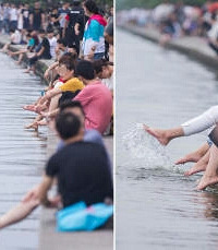 "西湖成洗脚池 众多游客将脚伸进湖水里泡脚戏水"