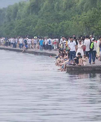 "西湖成洗脚池 众多游客将脚伸进湖水里泡脚"