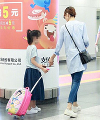 袁泉带女儿现身机场 小姑娘自推行李好懂事