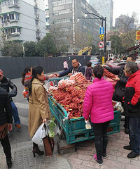 "杭州市区街头流动摊贩卖生的小红薯和红萝卜,大妈和大爷围观买.