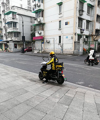 这个外卖小哥够拼的,拿着两个外卖保温箱子送外卖