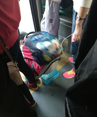 小学生坐在自己的饭盒上