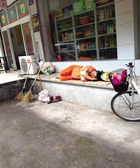 环卫工阿姨 睡在路边的硬板纸上(图)