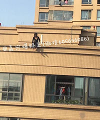 突发!嘉兴某小区一年轻女子披头散发坐在天台上 疑似要跳楼?