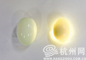 右边的是鸽子蛋,用手电筒一照,整颗蛋都亮了起来.  记者 许康平 摄