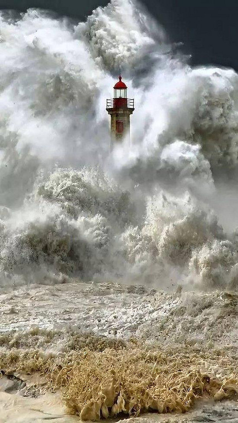 14. 海上的灯塔经受着巨浪的袭击